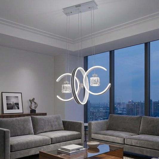Dual crescent moon LED pendant light installed above grey sofas in a modern living room.