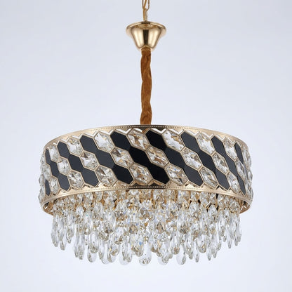Gold-finished circular chandelier with black inlay panels and hanging crystal prisms, shown on a white background.