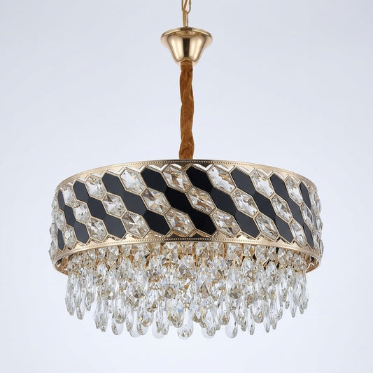 Gold-finished circular chandelier with black inlay panels and hanging crystal prisms, shown on a white background.