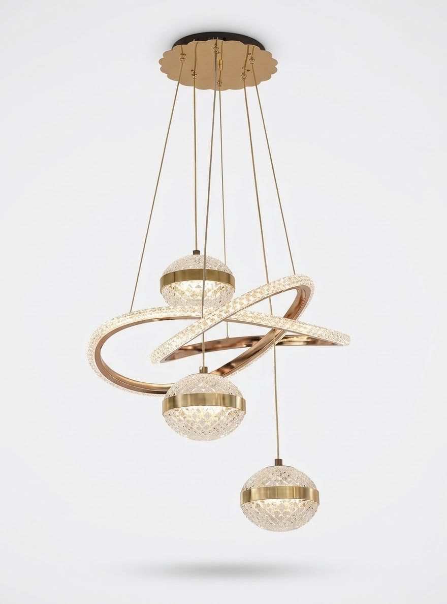 Gold LED multi-drop pendant light with sweeping rings and three crystal-effect globes, shown on a white background.