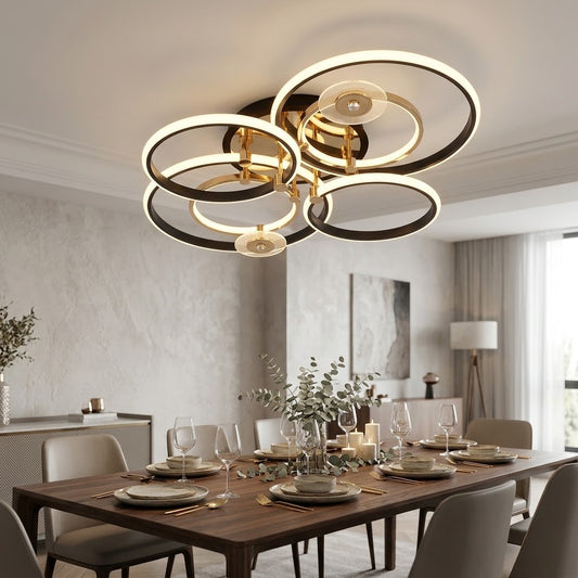 Luxury LED ceiling light with black and gold rings installed above a dining table.