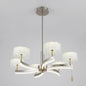 Gold-finished LED pendant chandelier with sculptural curved arms and textured crystal drum shades, shown on a white background.