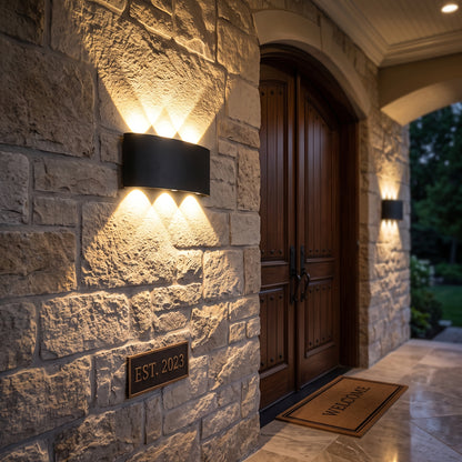 Close-up of the black LED wall sconce showing the crisscross beam pattern.