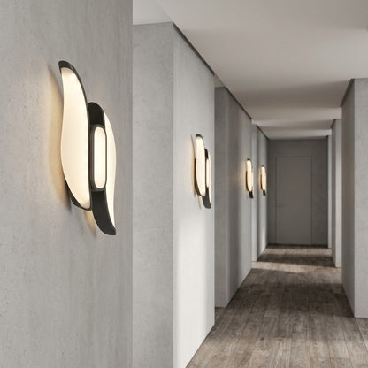 Sculptural LED wall light in black finish, shown on a white background.