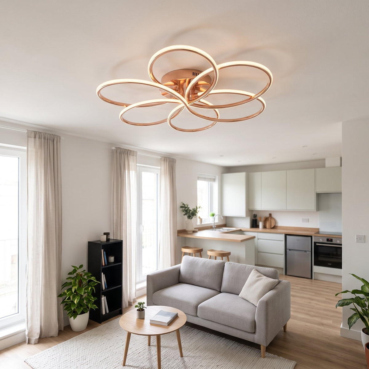 A modern LED ceiling light shaped like a flower, with six sweeping loops in a polished rose gold finish