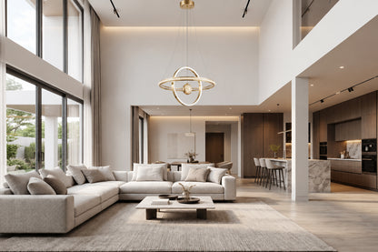 A modern LED pendant light in polished gold, featuring two interlocking illuminated rings arranged around a crystal-textured centre globe..