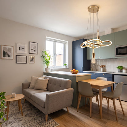 A modern pendant light with a sculptural, flowing gold LED ribbon that loops and twists, with two crystal-bubble teardrop pendants hanging from it. .