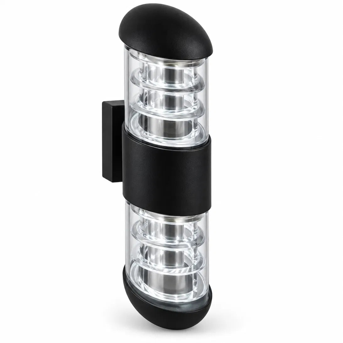 A Sunrise Lion rounded outdoor wall lantern in black aluminium and glass, with a domed cap and a ribbed cage design that casts a warm, decorative glow on the wall.