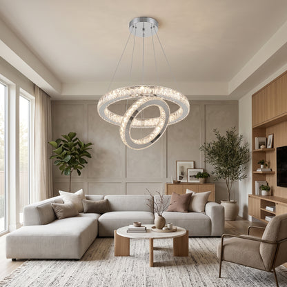 Two-ring chrome crystal chandelier hanging in a bright modern living room with a light grey sectional sofa