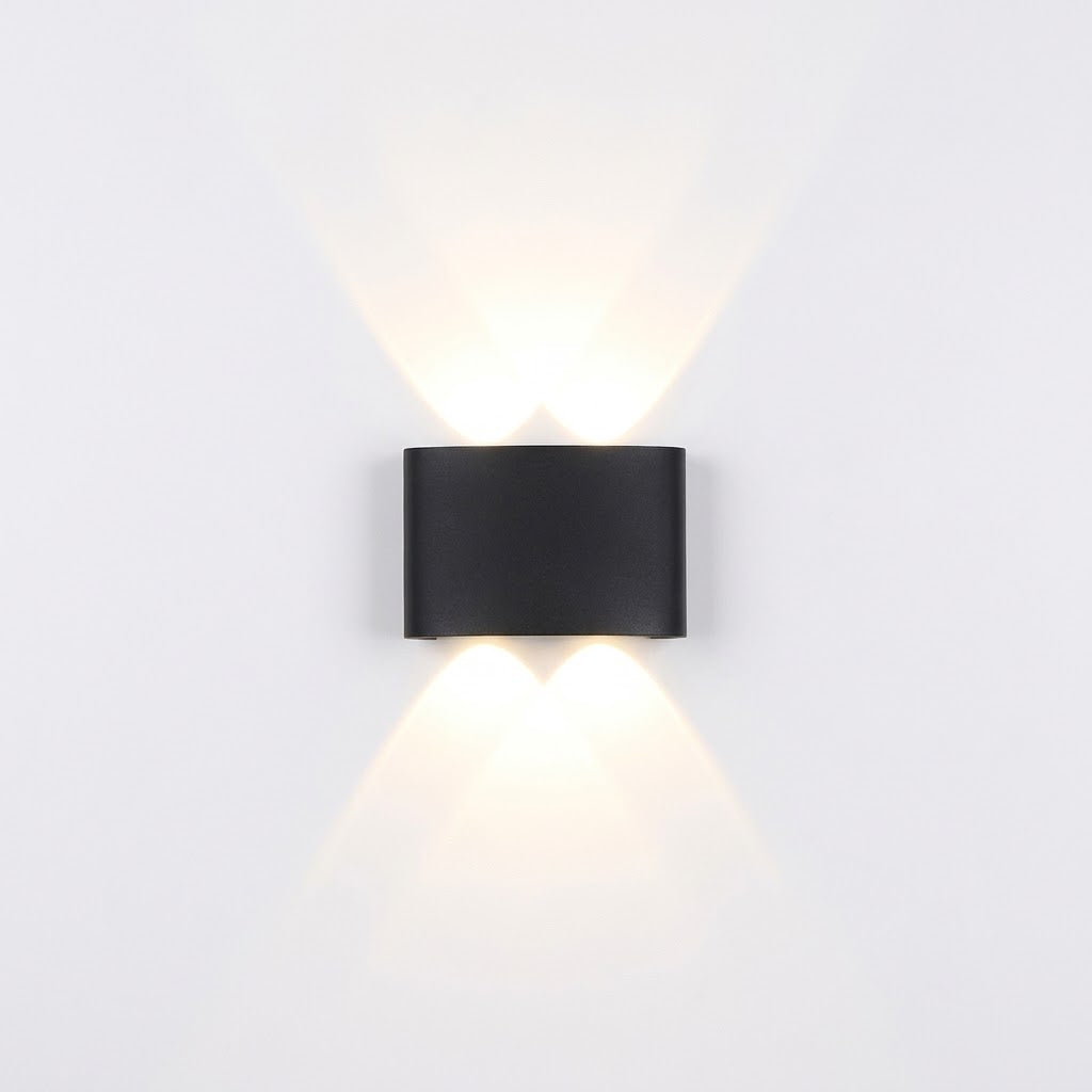 Black LED wall sconce installed beside a front door, illuminated at dusk.