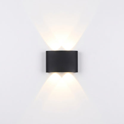 Black LED wall sconce installed beside a front door, illuminated at dusk.